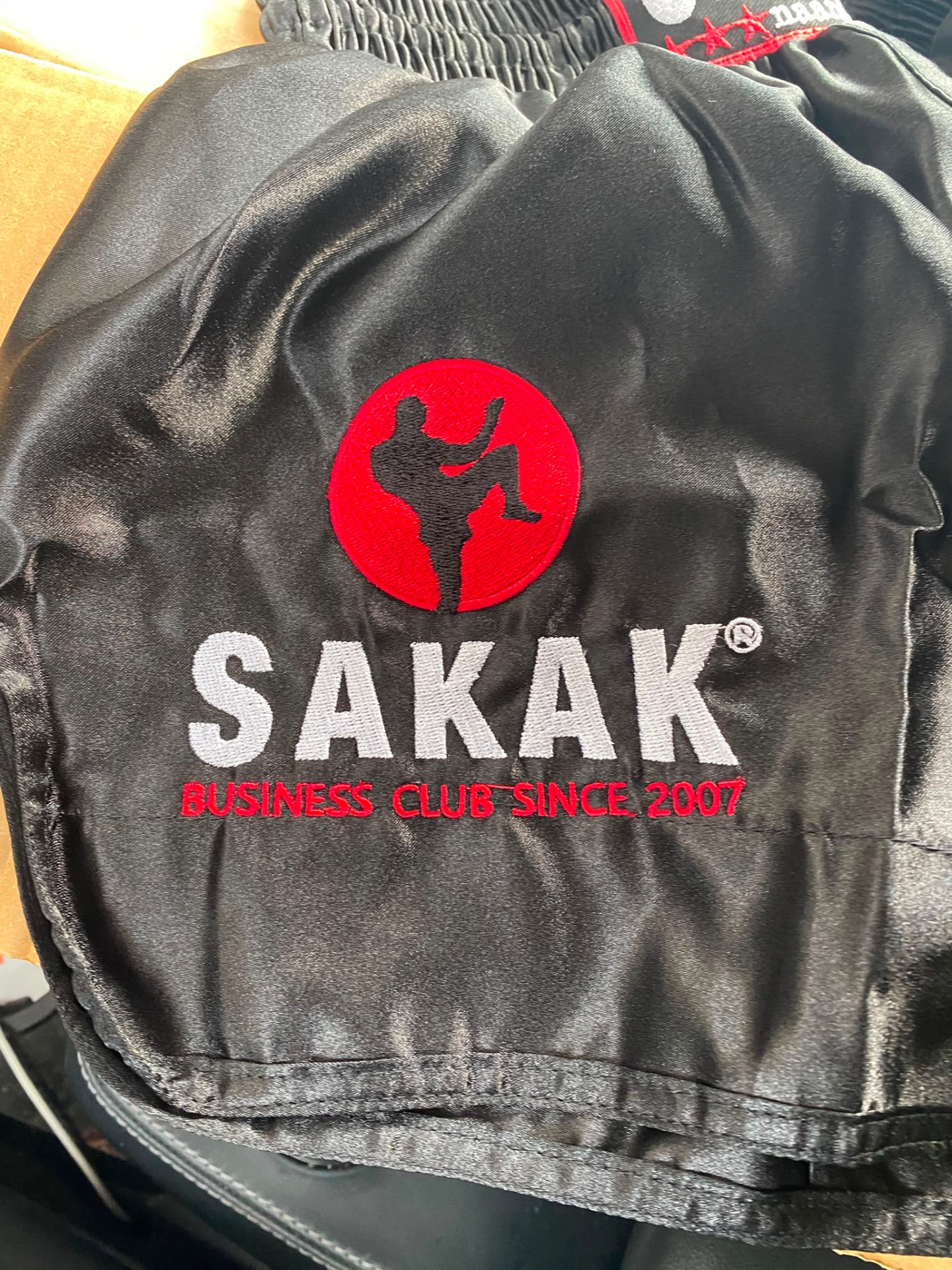 Zwarte SAKAK-kickboksbroek met rood clublogo en de tekst Business Club Since 2007