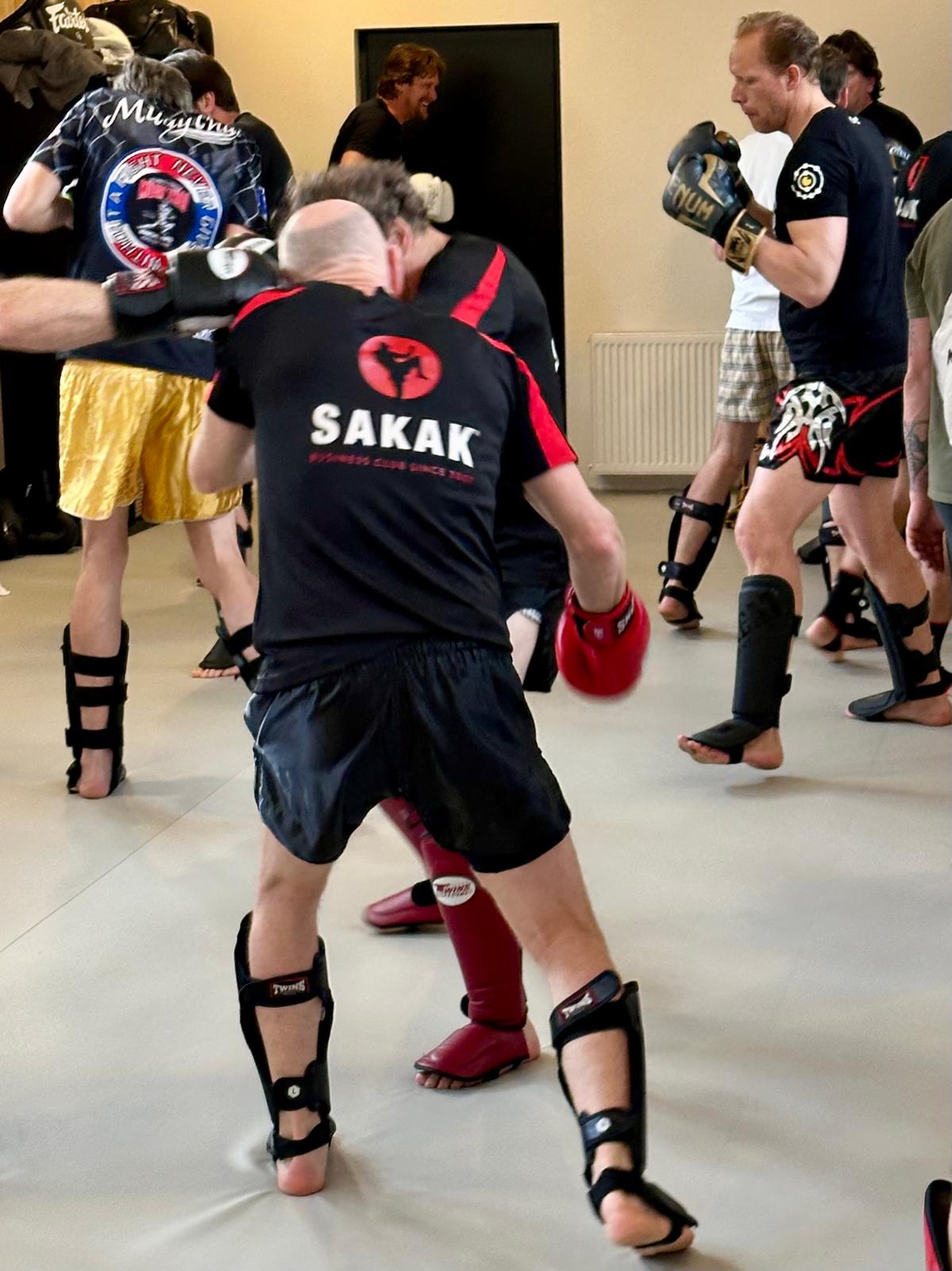 Twee SAKAK-leden sparren met handschoenen en scheenbeschermers in de zaal