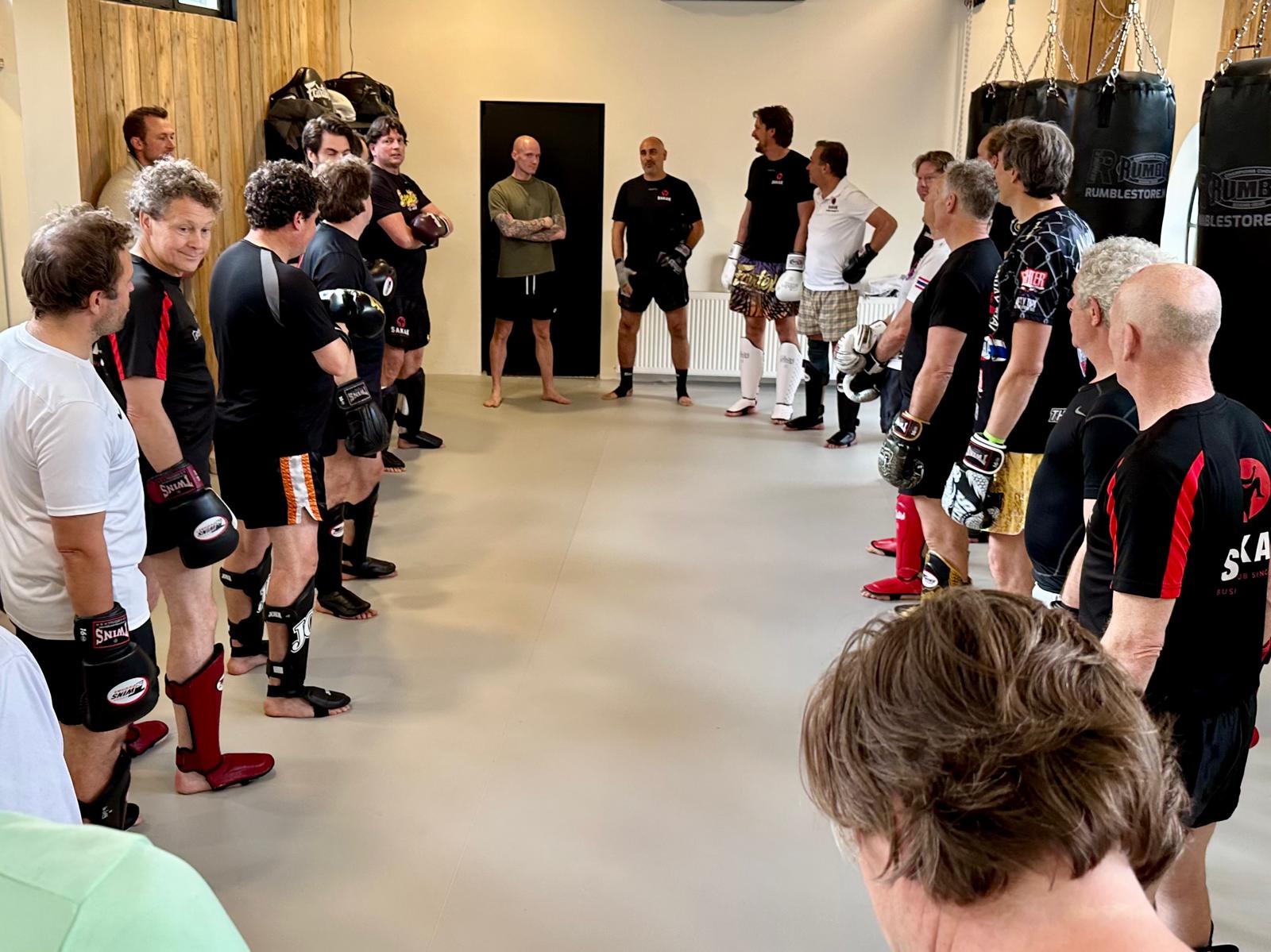 SAKAK-leden staan in een kring in de trainingszaal in Naarden voor aanvang van de les